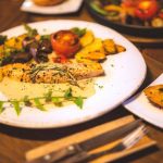 Fish served with squash and colorful vegetables