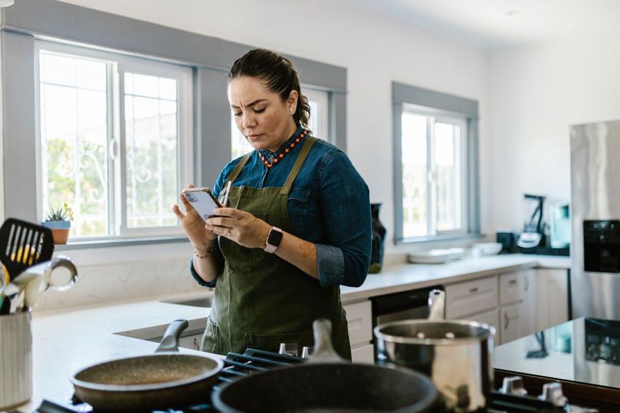 Cook checks recipe details on a phone