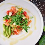Salmon served with colorful vegetables and herbs