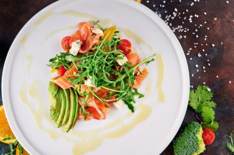 Salmon served with colorful vegetables and herbs