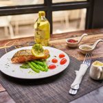 Salmon served with colorful vegetables and greens