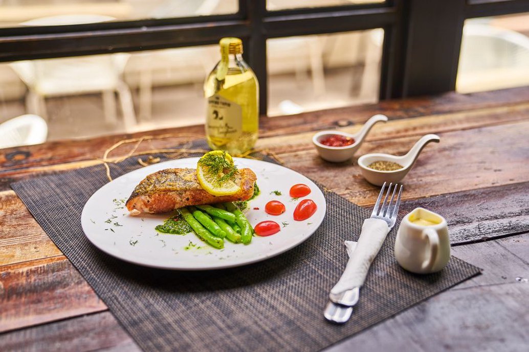Salmon served with colorful vegetables and greens