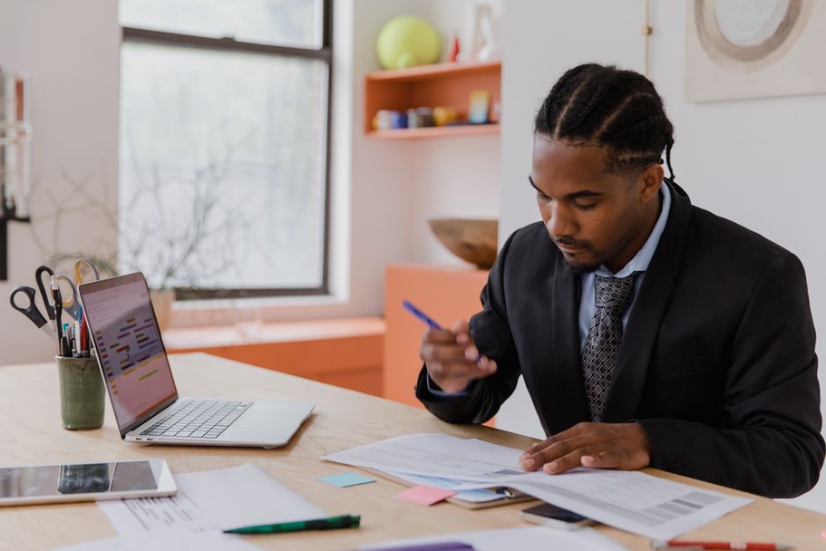 Notes and calendar beside an open laptop