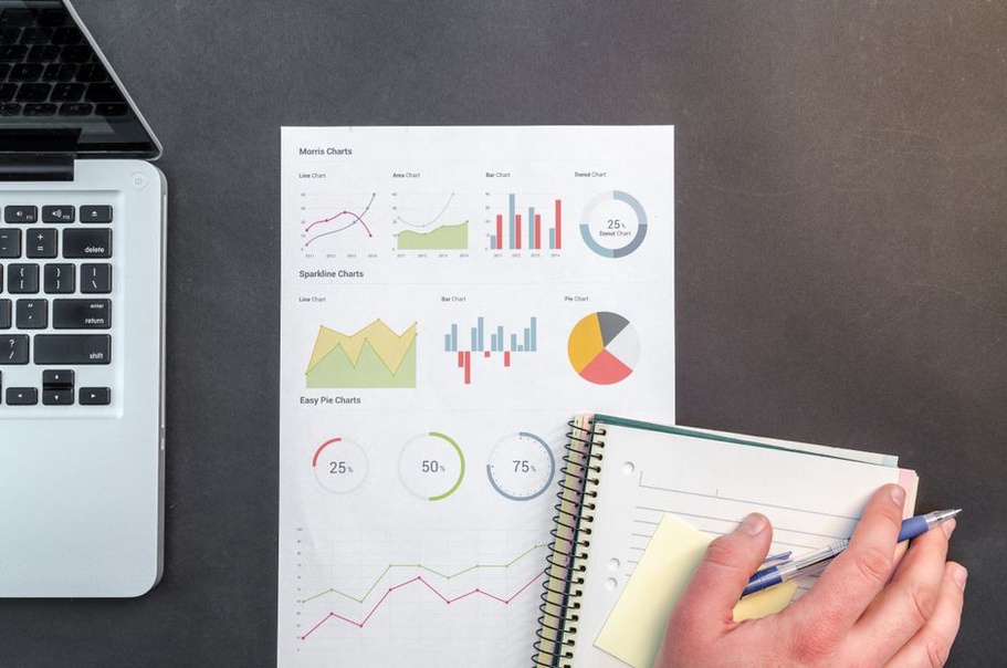 Notebook with page goals beside an analytics screen